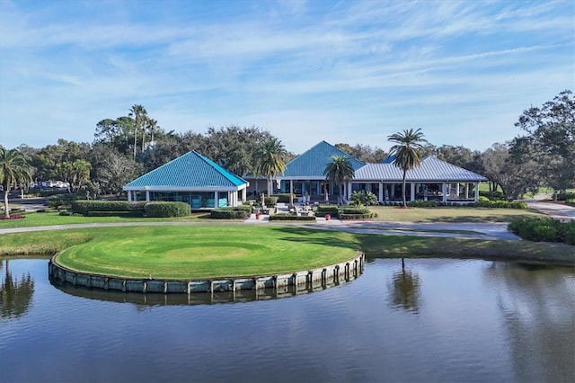 surrounding community with a water view and a lawn