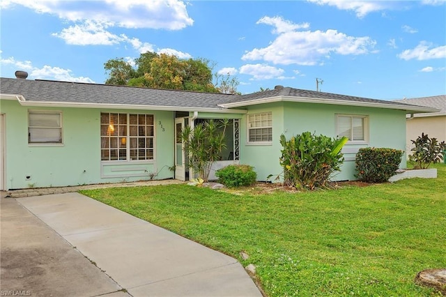 ranch-style house featuring roof with shingles, a front lawn, and stucco siding