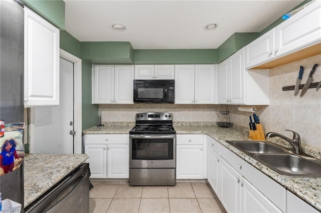 kitchen featuring light countertops, decorative backsplash, appliances with stainless steel finishes, white cabinetry, and a sink