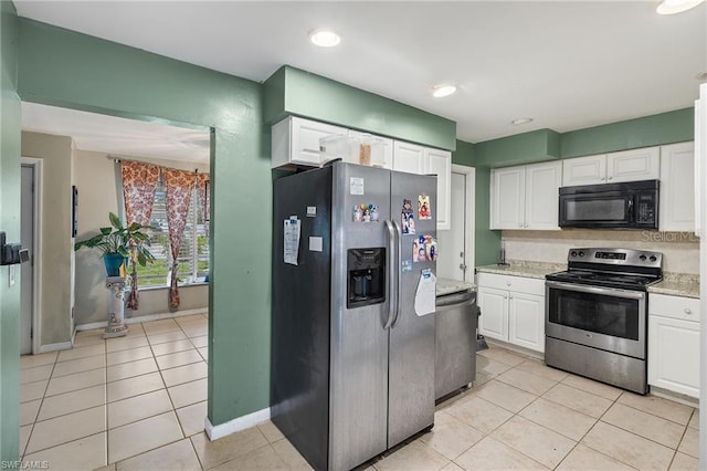 kitchen featuring appliances with stainless steel finishes, light tile patterned flooring, and white cabinetry