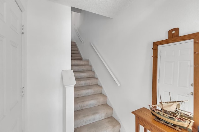 staircase with a textured ceiling