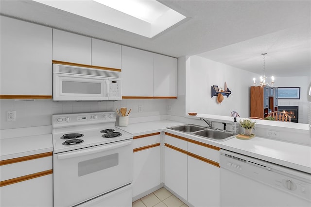 kitchen with white appliances, white cabinetry, light countertops, and a sink