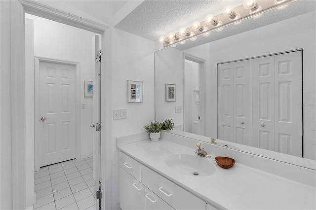 bathroom featuring a closet, a textured ceiling, vanity, and tile patterned floors