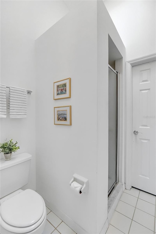 bathroom with toilet, tile patterned flooring, baseboards, and a shower stall