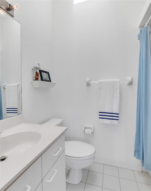 bathroom with baseboards, vanity, toilet, and tile patterned floors