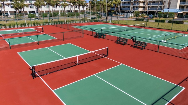 view of tennis court with community basketball court and fence