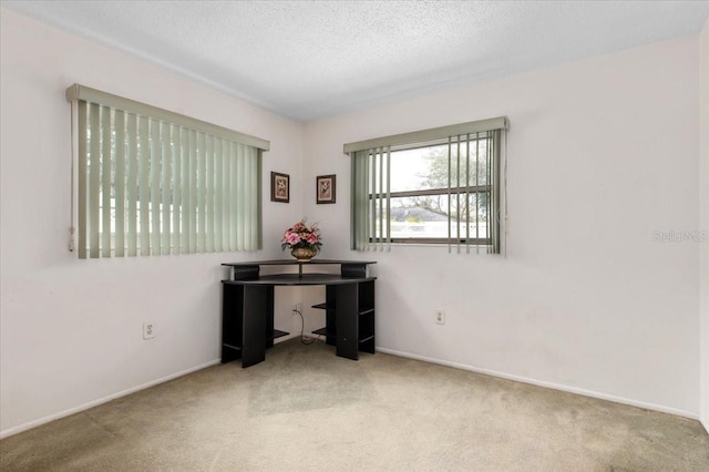 home office with carpet, a textured ceiling, and baseboards