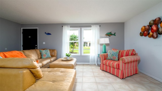 living room featuring light tile patterned floors, baseboards, and a textured ceiling