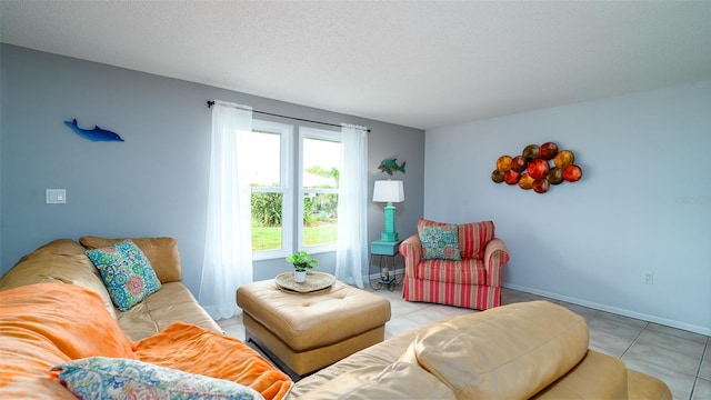 living area with a textured ceiling, light tile patterned flooring, and baseboards