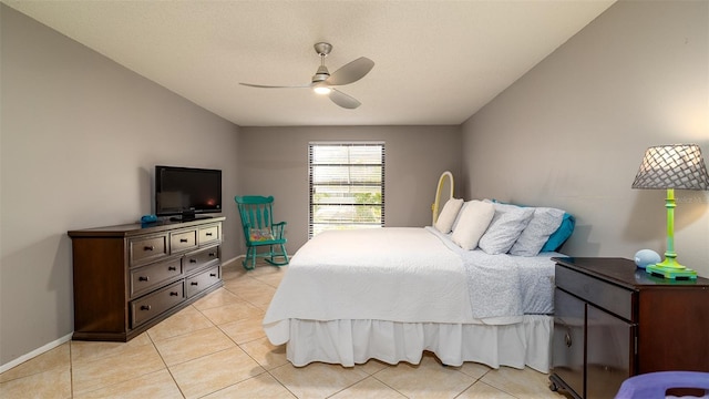 bedroom with a ceiling fan, vaulted ceiling, baseboards, and light tile patterned floors