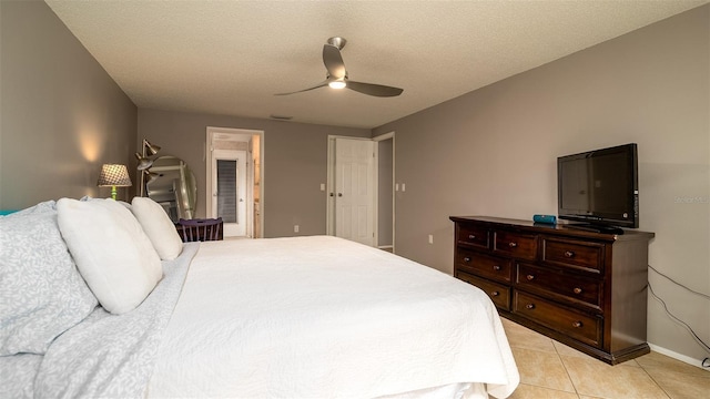 bedroom featuring ceiling fan, a textured ceiling, and light tile patterned floors