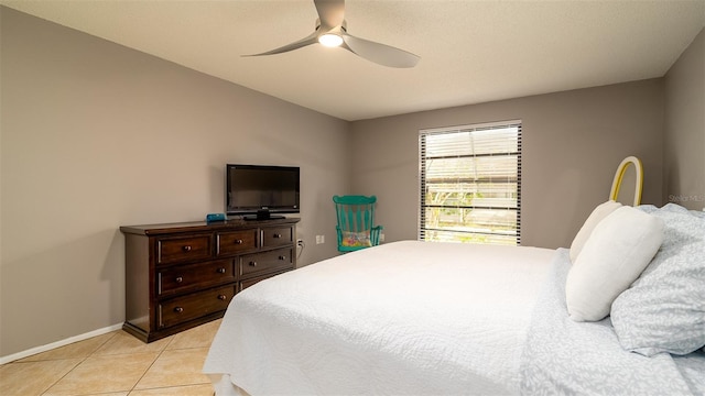 bedroom with a ceiling fan, baseboards, and light tile patterned floors