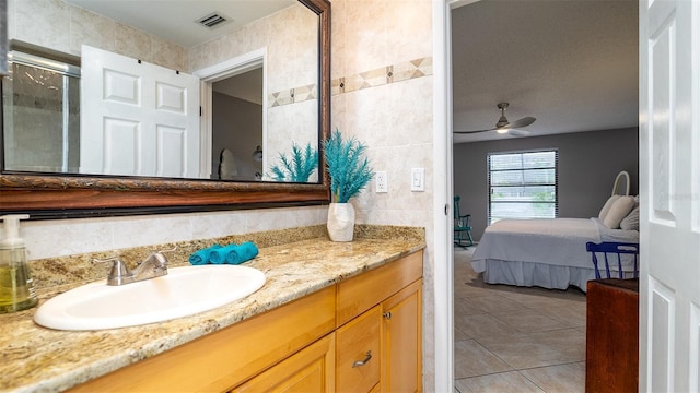 full bathroom featuring tile patterned flooring, connected bathroom, vanity, a ceiling fan, and visible vents