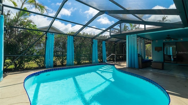 outdoor pool with glass enclosure and a patio area