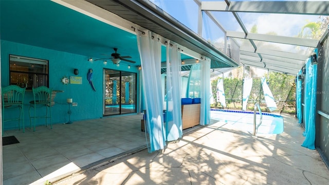 view of patio / terrace with a lanai, ceiling fan, and an outdoor pool