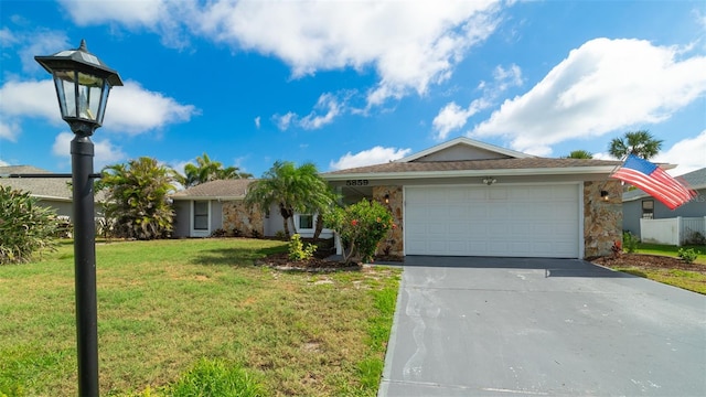 single story home featuring a garage, a front lawn, and concrete driveway