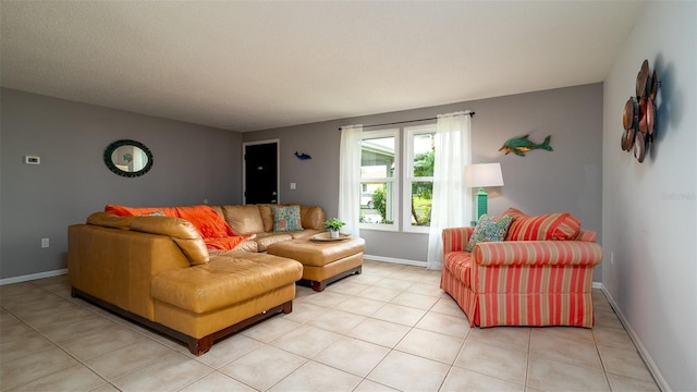 living room with baseboards, a textured ceiling, and light tile patterned floors