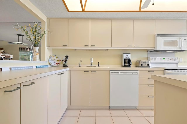 5740 Midnight Pass Rd Unit 402, Sarasota, FL 34242 - kitchen featuring light tile patterned floors, white appliances, a sink, light countertops, and cream cabinetry