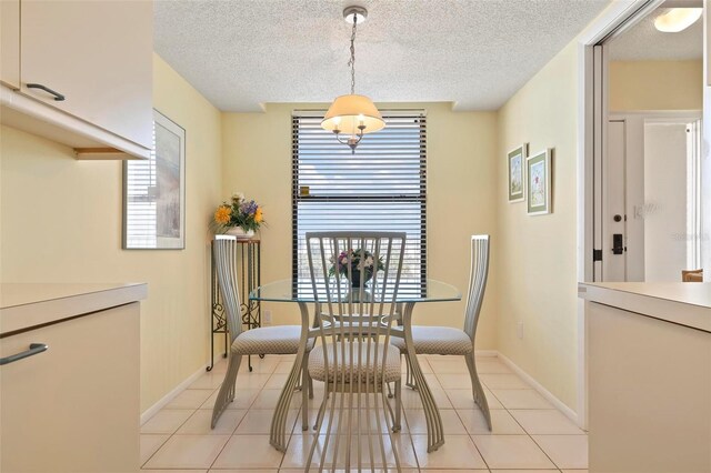 5740 Midnight Pass Rd Unit 402, Sarasota, FL 34242 - dining space featuring a textured ceiling, light tile patterned floors, and baseboards