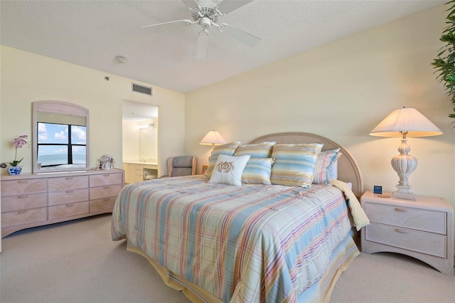 5740 Midnight Pass Rd Unit 402, Sarasota, FL 34242 - bedroom with a textured ceiling, ceiling fan, connected bathroom, light colored carpet, and visible vents