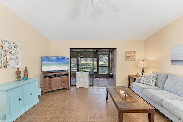 living room featuring lofted ceiling, light tile patterned flooring, ceiling fan, and a textured ceiling