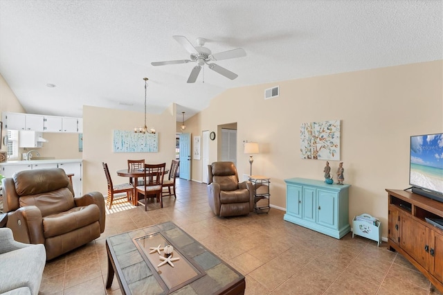 living room featuring lofted ceiling, light tile patterned floors, a textured ceiling, and visible vents