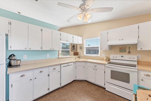 kitchen with white appliances, a sink, white cabinetry, and under cabinet range hood