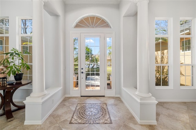 doorway with baseboards, a healthy amount of sunlight, and ornate columns