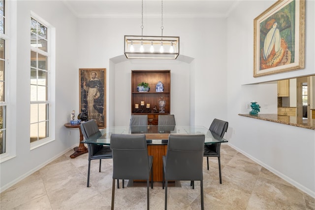 dining area with ornamental molding, plenty of natural light, and baseboards