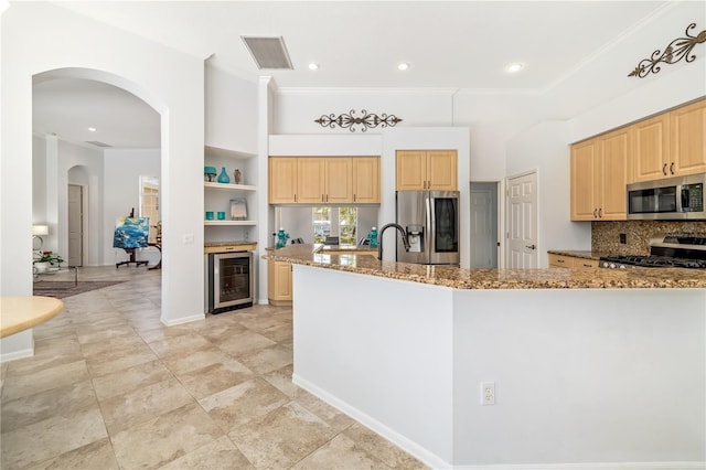 kitchen with stone countertops, visible vents, wine cooler, stainless steel appliances, and light brown cabinets