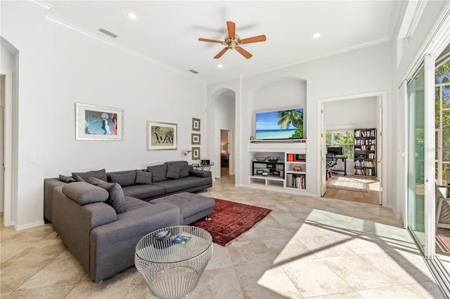 living room with visible vents, arched walkways, a towering ceiling, ornamental molding, and recessed lighting