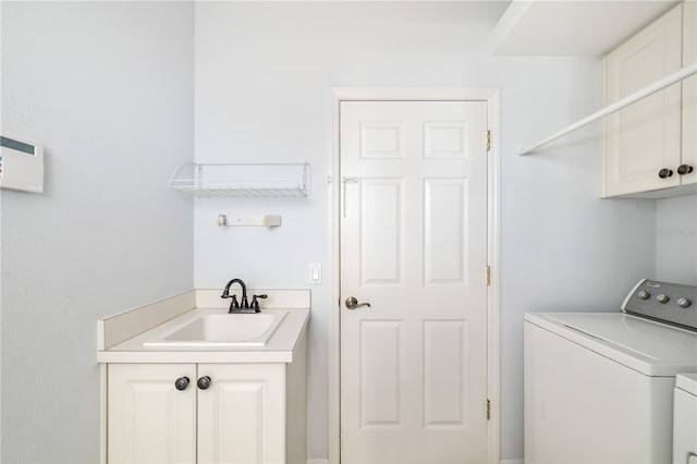 laundry area with cabinet space, a sink, and washing machine and clothes dryer