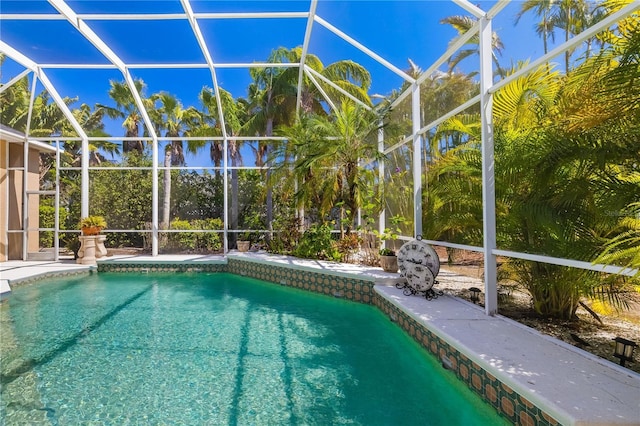 outdoor pool featuring glass enclosure and a patio area