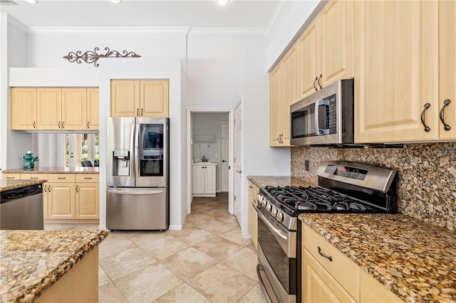 kitchen with stainless steel appliances, light stone countertops, ornamental molding, and tasteful backsplash