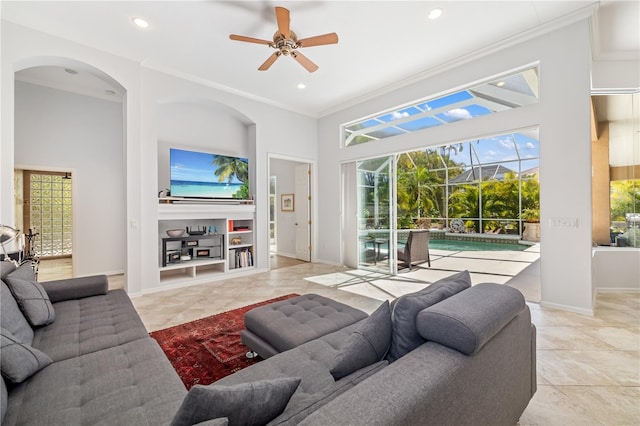 living area with crown molding, recessed lighting, a towering ceiling, a sunroom, and baseboards