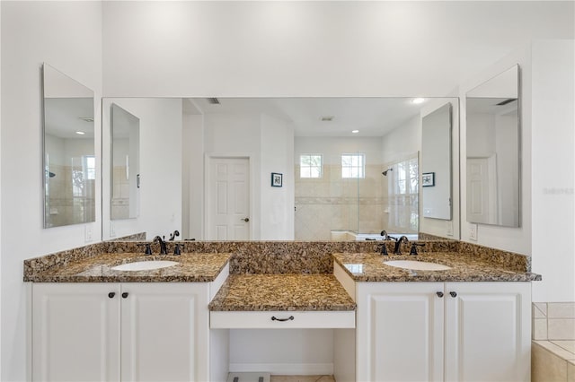 full bath featuring two vanities, a sink, and tiled shower