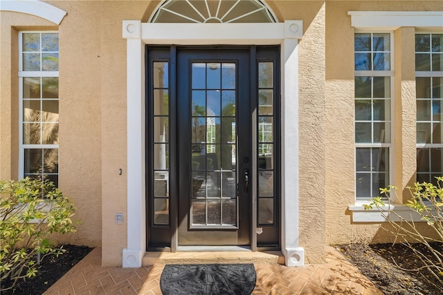 doorway to property featuring stucco siding