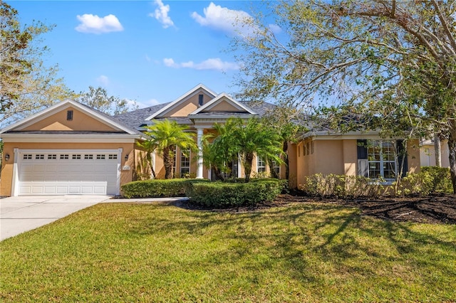 view of front facade with an attached garage, a front yard, concrete driveway, and stucco siding