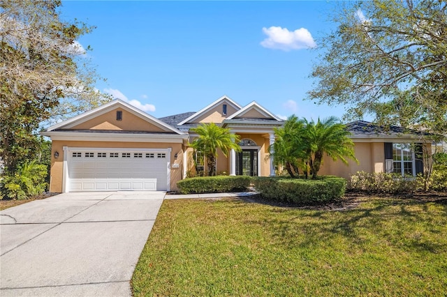 view of front of property featuring a garage, driveway, a front yard, and stucco siding