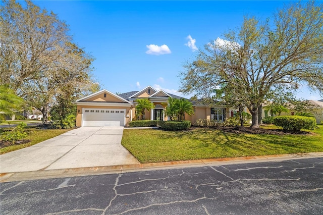 view of front of home with an attached garage, driveway, a front yard, and stucco siding