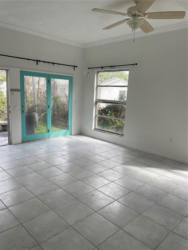 tiled spare room with baseboards, a ceiling fan, and crown molding