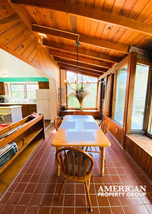 interior space with a healthy amount of sunlight, wood walls, and dark tile patterned floors