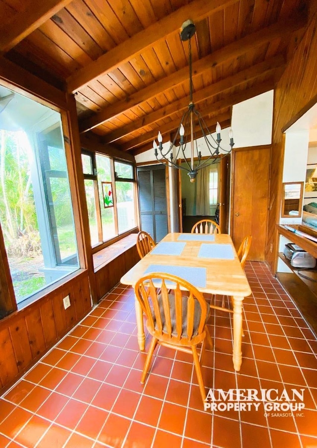 tiled dining room featuring a chandelier, wood ceiling, wooden walls, and lofted ceiling with beams