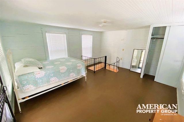 bedroom featuring finished concrete flooring and a closet