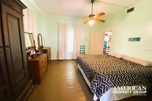 bedroom featuring dark wood-style floors, visible vents, and ceiling fan