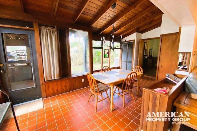 dining space with tile patterned flooring, wood ceiling, vaulted ceiling with beams, and wooden walls