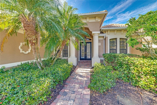 view of exterior entry with stucco siding and french doors