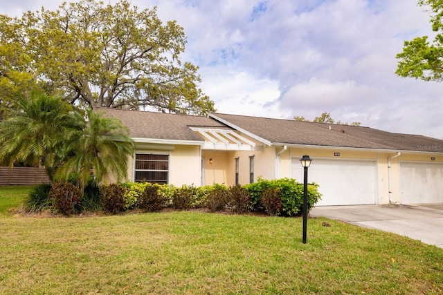 view of front facade with a front yard, driveway, and stucco siding