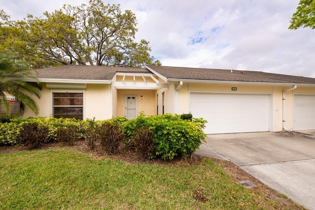 view of front of house with concrete driveway, an attached garage, and stucco siding