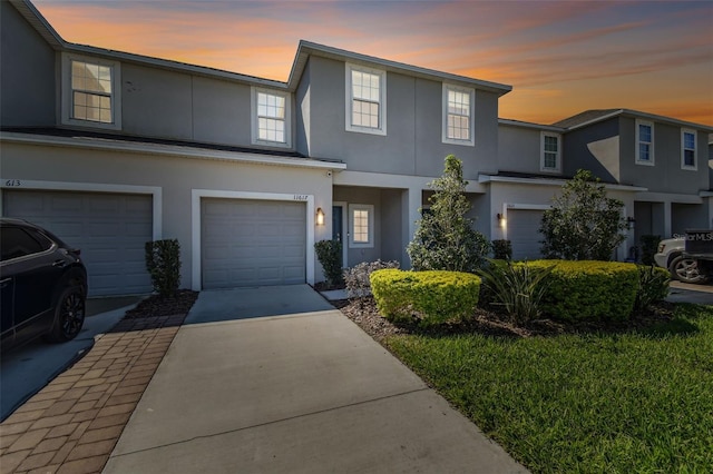 view of front of home featuring a garage, driveway, and stucco siding